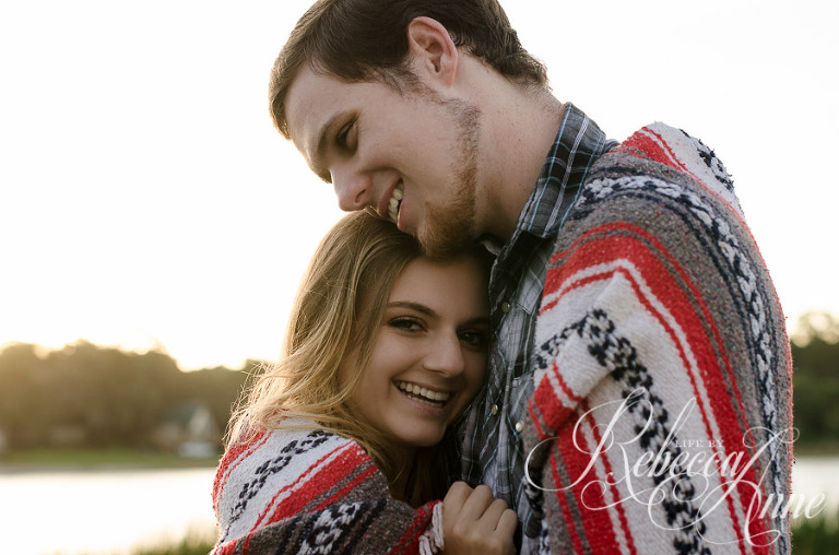 engagement couple, lake, couple, sunrise, embrace, hug, smile, blanket