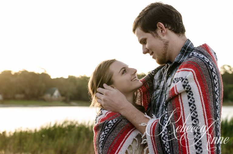 engagement couple, lake, couple, sunrise, embrace, hug, smile, blanket