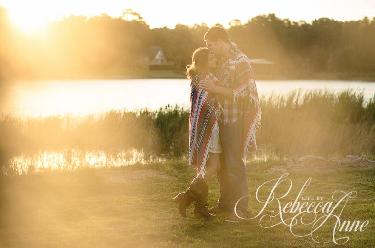 engagement couple, lake, couple, sunrise, embrace, hug, smile, blanket, sun, flares